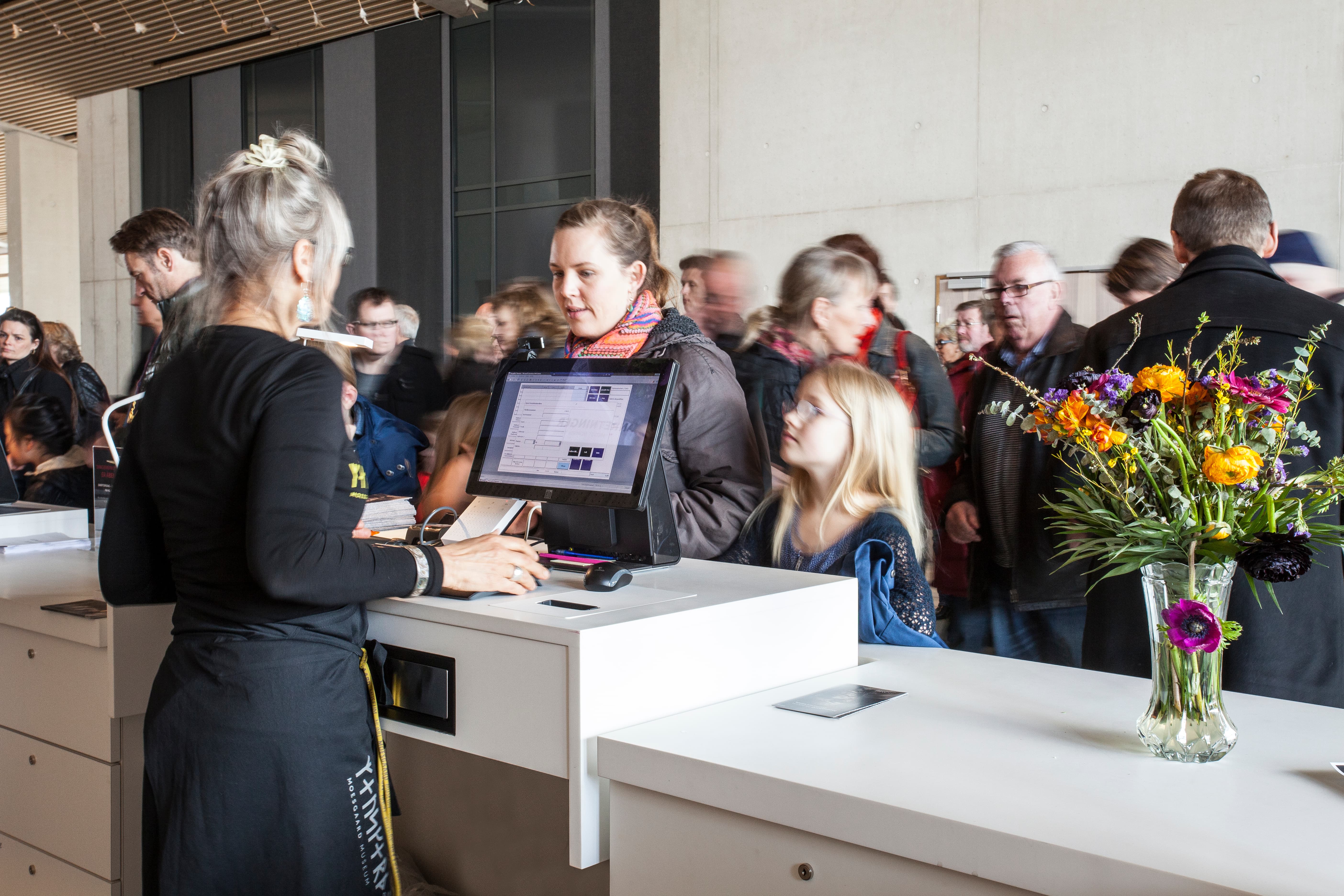 woman using POS system to serve customers at front desk